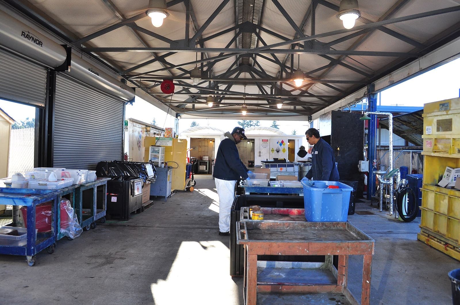 Fasilitas pengumpulan limbah berbahaya dengan meja pemilahan dan wadah